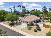 Charming single-story home with lush landscaping, a terracotta tile roof, and a spacious two-car garage at 108 E Horseshoe Ave, Gilbert, AZ 85296