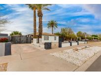 Charming single-story home featuring a white exterior, desert landscaping, and mature palm trees at 1529 E Edgemont Ave, Phoenix, AZ 85006