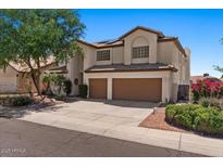 Charming two-story home featuring a two-car garage, desert landscaping, and a beautiful tree in the front yard at 15829 S 13Th Pl, Phoenix, AZ 85048