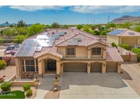Elegant two-story home with tile roof, solar panels, three-car garage, and inviting front porch with seating at 24916 N 80Th Ln, Peoria, AZ 85383