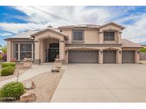 Charming two-story home with a three-car garage, covered entry, tile roof, and desert landscaping at 24916 N 80Th Ln, Peoria, AZ 85383