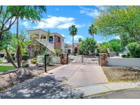 Stunning two-story home featuring stone accents, a tile roof, and a gated driveway entrance at 2527 E Beechnut Ct, Chandler, AZ 85249