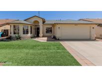 Charming single-story home featuring a well-manicured lawn and an attached two-car garage at 4117 W Whispering Wind Dr, Glendale, AZ 85310