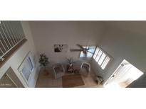 A bright living room with two cozy chairs, a ceiling fan, and large windows with shutters for natural light at 475 S Seawynds Blvd, Gilbert, AZ 85233