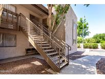 Apartment staircase with well maintained landscaping and neutral color scheme at 520 N Stapley Dr # 253, Mesa, AZ 85203