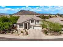 Charming two-story home boasts a desert landscape, tile roof, mountain views, and attached two car garage at 6026 E Sonoran Trl, Scottsdale, AZ 85266