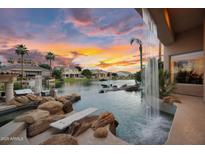 Waterfront pool features a waterfall, diving board, and stunning sunset views at 633 W Aster Ct, Chandler, AZ 85248
