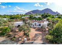 Stunning single-story home featuring a red tile roof, circular driveway, and mature landscaping with a mountain view at 6701 E San Miguel Ave, Paradise Valley, AZ 85253