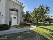 Charming home featuring a white door, desert landscaping, mature trees, and a well manicured lawn at 8180 E Shea Blvd # 1028, Scottsdale, AZ 85260