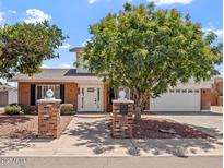 Charming two-story home with brick accents, a lush tree, and a well-manicured front yard at 8545 E Heatherbrae Dr, Scottsdale, AZ 85251