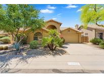 Charming single-story home featuring a tile roof, desert landscaping, and a spacious driveway at 9127 E Siesta Ln, Scottsdale, AZ 85255