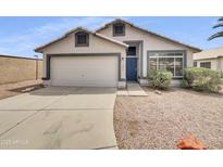 Charming single-story home with a two-car garage, blue door, and low-maintenance landscaping at 1211 S Pueblo Ct, Gilbert, AZ 85233