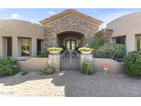 Elegant stone archway and gated entry enhance the curb appeal of this beautiful desert home at 13249 E Summit Dr, Scottsdale, AZ 85259