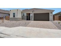 Charming single-story home with a desert landscape, brick driveway, and a two car garage at 18522 W Mohave St, Goodyear, AZ 85338