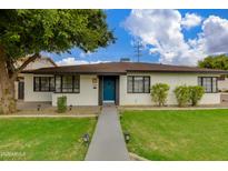 Charming single-story home with a well-manicured lawn, blue front door, and a welcoming walkway at 2501 E Campbell Ave, Phoenix, AZ 85016