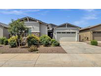 Charming single-story home with a two-car garage, stone accents, and lush desert landscaping at 2962 E Birdsong Ave, San Tan Valley, AZ 85143