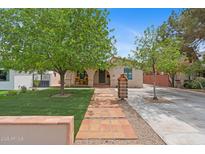 Charming home with inviting walkway, lush lawn, and mature trees providing curb appeal at 307 E Catalina Dr, Phoenix, AZ 85012