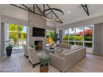 Bright living room features a concrete fireplace, hardwood floors, and large windows with views of the pool at 4416 N 37Th Way, Phoenix, AZ 85018