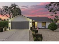 Charming home with a two-car garage, manicured landscaping, and inviting curb appeal at twilight at 5238 E Beck Ln, Scottsdale, AZ 85254