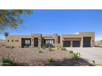 Contemporary home featuring a stone accent entry, desert landscaping, and a spacious driveway leading to a two-car garage at 532 E Paint Your Wagon Trl, Phoenix, AZ 85085