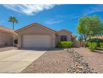 Charming single-story home with a well-maintained yard, desert landscaping, and a two-car garage at 6027 E Sayan Cir, Mesa, AZ 85215