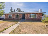 Charming single-story brick home with a well-maintained front yard and walkway at 3107 W Tuckey Ln, Phoenix, AZ 85017