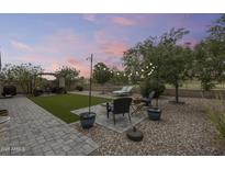 Expansive backyard featuring a patio, lush trees, and a charming pergola for outdoor relaxation at 35773 N Loemann Dr, San Tan Valley, AZ 85143