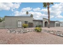 Charming single-story home with desert landscaping, mature palm trees, and neutral-colored exterior at 5119 E Shaw Butte Dr, Scottsdale, AZ 85254