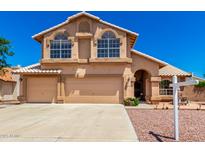 Charming two-story home featuring a three-car garage and decorative architectural details at 5216 W Oraibi Dr, Glendale, AZ 85308