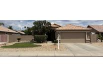 Charming single-story home featuring a well-maintained lawn and two-car garage at 624 E Iris Ct, Gilbert, AZ 85296