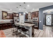Spacious kitchen with large island, granite countertops, stainless appliances, and dark wood cabinetry at 10738 W Rowel Rd, Peoria, AZ 85383