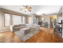 Inviting living room features a plush sectional sofa, ottoman, and hardwood floors at 16600 N Thompson Peak Pkwy # 2006, Scottsdale, AZ 85260