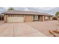 Charming single-story home features a brick exterior and a two-car garage and neutral gravel landscaping at 2502 S Mollera Cir, Mesa, AZ 85210