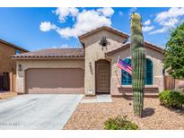 Charming stucco home featuring a desert landscape, attached two-car garage, and a welcoming front entrance at 41342 W Elm Dr, Maricopa, AZ 85138