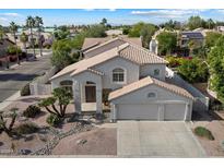 Two-story home showcasing a three-car garage and a well-maintained desert-style front yard with decorative rock landscaping at 5402 E Helena Dr, Scottsdale, AZ 85254