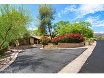 Well maintained home with lush landscaping and a circular driveway on a sunny day at 5536 N Camelback Canyon Pl, Phoenix, AZ 85018