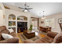 Open concept living area featuring a ceiling fan, large sofa, and dining table with backyard access at 641 W Mesquite Tree Ln, San Tan Valley, AZ 85143