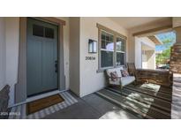Inviting front porch features stylish decor, neutral stucco, stacked stone accents, and a welcoming entrance at 20834 W Prospector Way, Buckeye, AZ 85396