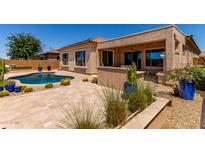 Landscaped backyard featuring a pool, desert plants, and covered patio area for relaxing and entertaining at 27537 W Yukon Dr, Buckeye, AZ 85396