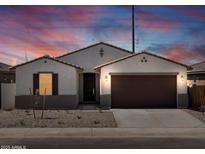 Charming single-story home featuring neutral stucco, a tile roof and a two-car garage at 37385 W San Sisto Ave, Maricopa, AZ 85138