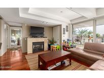 Cozy living room with a fireplace, wood floors, and large sliding doors to balcony at 7167 E Rancho Vista Dr # 4011, Scottsdale, AZ 85251