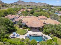 Stunning aerial view of estate featuring a pool, spa, lush landscaping, and a gorgeous home with a Spanish tile roof at 8329 N Ridgeview Dr, Paradise Valley, AZ 85253
