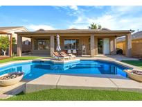 Inviting backyard oasis with a sparkling pool, lounge chairs, and a covered patio, perfect for relaxation and outdoor entertaining at 10909 W Chase Ln, Avondale, AZ 85323