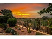 A charming backyard view with desert landscaping, and an orange sunset at 11553 W Cottontail Ct, Surprise, AZ 85378