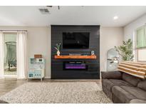 Comfortable living room featuring a modern electric fireplace and a cozy seating area at 13380 N 148Th Ave, Surprise, AZ 85379