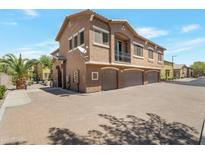 Attractive townhome featuring a three-car garage, desert landscaping, and neutral color palette at 15240 N 142Nd Ave # 2171, Surprise, AZ 85379