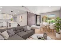 Bright living room featuring a modern sectional sofa, a dining area, and an open-concept kitchen at 1624 E Campbell Ave # 51, Phoenix, AZ 85016