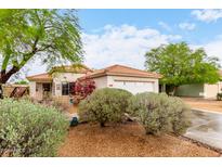 Charming single-story home featuring a red tile roof, desert landscaping, and a cozy front porch at 17128 N Princess Pl, Surprise, AZ 85374
