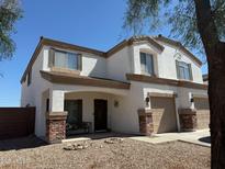 Charming two-story home featuring a covered porch and a two-car garage, set against a clear blue sky at 22966 W Hopi St, Buckeye, AZ 85326