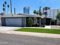 Charming single-story home boasts a well-manicured lawn, gray exterior, and a convenient attached garage in a sunny neighborhood at 3137 N 4Th Ave, Phoenix, AZ 85013